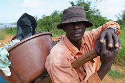 Fresco. man and heavy hand pulled fish cart, Cote d'Ivoire, Ivory Coast.