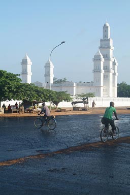 Yamoussoukro, white mosque, new black tarmac in front, shining reflecting light.