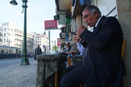 Man in cafe in Alexandria, lighting a cigarette.