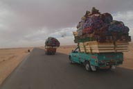 Overloaded pick-up trucks on route to Siva oasis, Harmattan heavy skies.