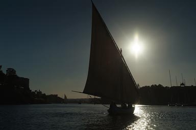 felucca silhuette against sun, Aswan Egypt.