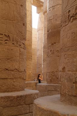 Tourist taking picture, Great Hypostyle Hall, between columns, Karnak Temple. 