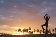 Sunset dance on beach, palm trees in red sky, girl dancing on beach.