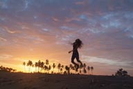 Sunset dance on beach, palm trees in red sky, girl dancing on beach.