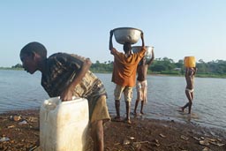 Lake Volta in Ghana, young children carry heavy load.