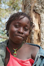 Daughter of Marie Toure, face of African girl, red blouse, jeans jacket, Guinea Bissau.