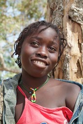 Daughter of Marie Toure, face of African girl, red blouse, jeans jacket, big smile, Guinea Bissau.