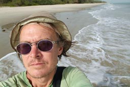 Me, white European, red short, green torn Langnesse, T-shirt, hat, standing on south beach of Bubaque, Arquipelago dos Bijagos. Islands. Guinea Bissau.