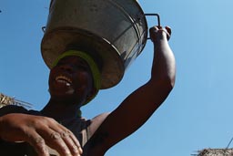 Woman carrying palm kernels.
