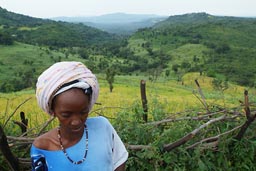 North of Guinea, Mali to Touba, near Medina Wora, Shy woman, rice fields in back.