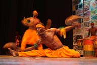 2 African male acrobats in orange light, stage Centre Culturelle Franco Guineen.