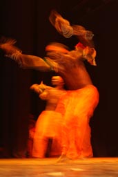 Tall African male dancer in orange light.