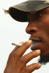 Conakry, island of Kassa, Lansana Camara and cigarette, African man with cap and beard smoking, Guinea, Guinee.