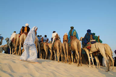 Tuareg woman passing by, men watching the show