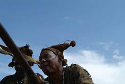 Donsow hunter with rifle against blue sky.