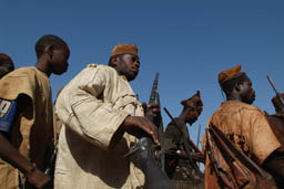 Donsow hunter with rifle against blue sky.