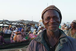 Man in Mopti, People boarding pirogues, Niger River, Mali.