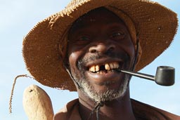 Portrait farmer with pipe, in Dogon country, some teeth missing, an axe, Mali.