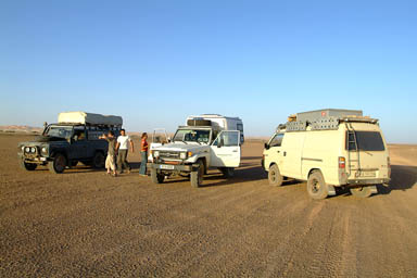 3 vehicles in flat desert