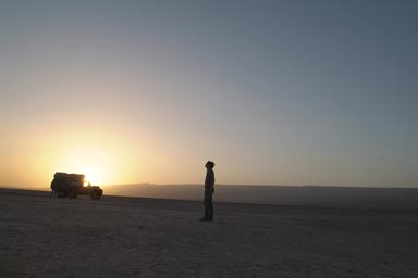 Land Rover against setting sun (sunset) and myself in Morocan flat desert, ms 