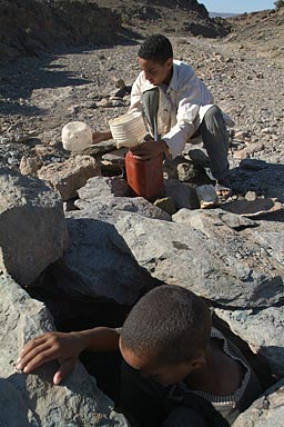 Fadele and his younger brother at the waterhole, Emptying it twice a day for maximum return.