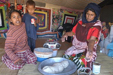 Mbarka preparing the dough, children watching, The radio is always put into the focus of the camera
