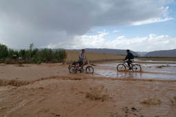 Flood destroyed wall, bikes through water.