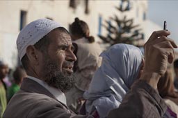 Muslim Moroccan takes pictures with his mobile phone on Gnaoua festival in Essaouira.