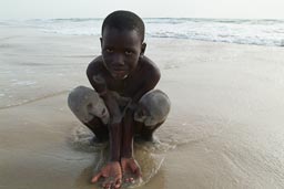 African boy, gather sea water in his hands, Casamance.