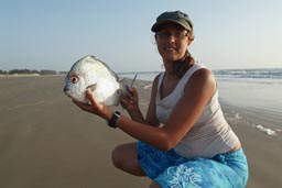 Hasna holds moon fish in Djembering beach, southern Senegal, Casamance.