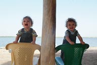 One year old, Daniel and David, standing on two chairs.