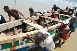 Fishermen pushing their boat.