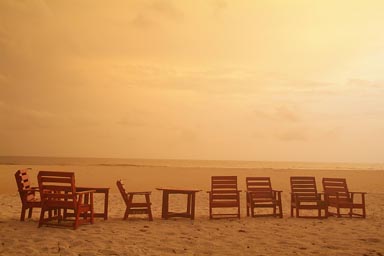Deck chairs on beach, dusk, clouds, yellow light, No2 river beach, Freetown peninsula, Sierra Leone.