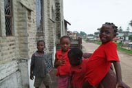 4 African children dressed in red on church steps. Close-up.