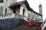 4 African children all dressed in red on church steps.