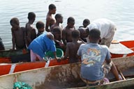 Harper, Liberia, children in pirogue, fish is being sold.