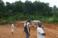 Muddy road in Liberia, 6x6 Defender stuck, behind long vehicle stuck, African people talk.