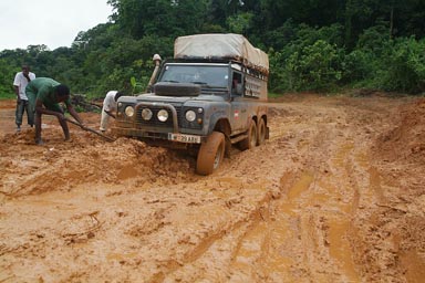 Slimy Mud, 6 wheeled Land Rover Defender stuck, Africans digging, Liberia.