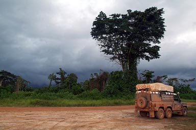 Thunder storm coming up, huge tropical tree, 6x6 Land Rover Defender, Liberia.