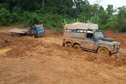 Rainy season, Land Rover stuck, behind blue truck stuck, road Liberia.