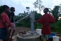 Antonio, African boy and some other girls and boys at water well, village of ITI, Liberia.
