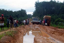 Truck stuck in hole, 6 wheeled Land Rover Defender next to it, Liberia.