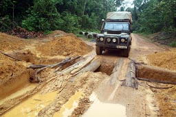 Building of road, River Cess to Greeville, Land Rover on little bridge of logs over ditch.