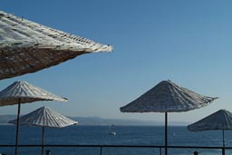 Straw umbrellas, restaurant terrace, Galipoli, Turkey, Dardanelles in back,