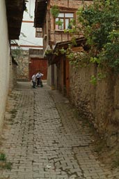 Children on bike play, cobblestone alley Safranbolu.