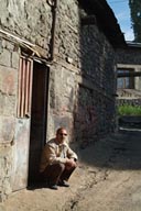 Man in Erzurum in front of door, smoking cigarette. Erzurum.