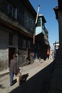 Man walks up sun lit street in Erzurum old district.
