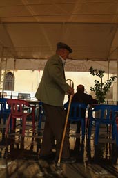 Old man, enters cafe terrace, Mardin, Turkey.