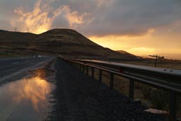 Sunshine reflection in puddle on wet road, Turkey.