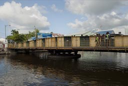 The hand operated, turning main bridge in old Belize City. Caribbean girls.